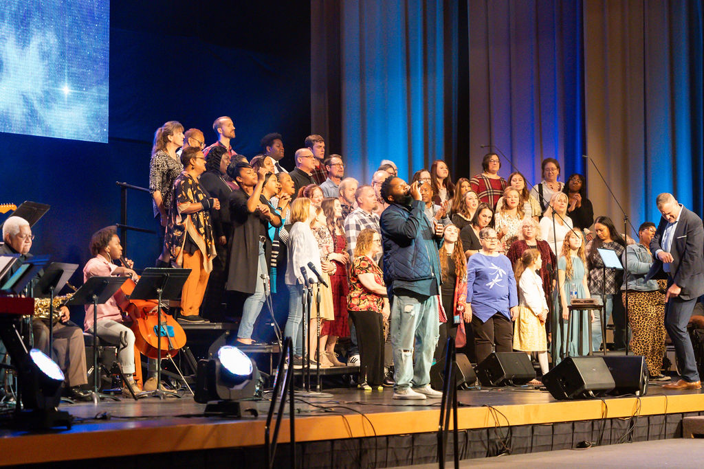 Diverse choir and congregation worshipping together on stage