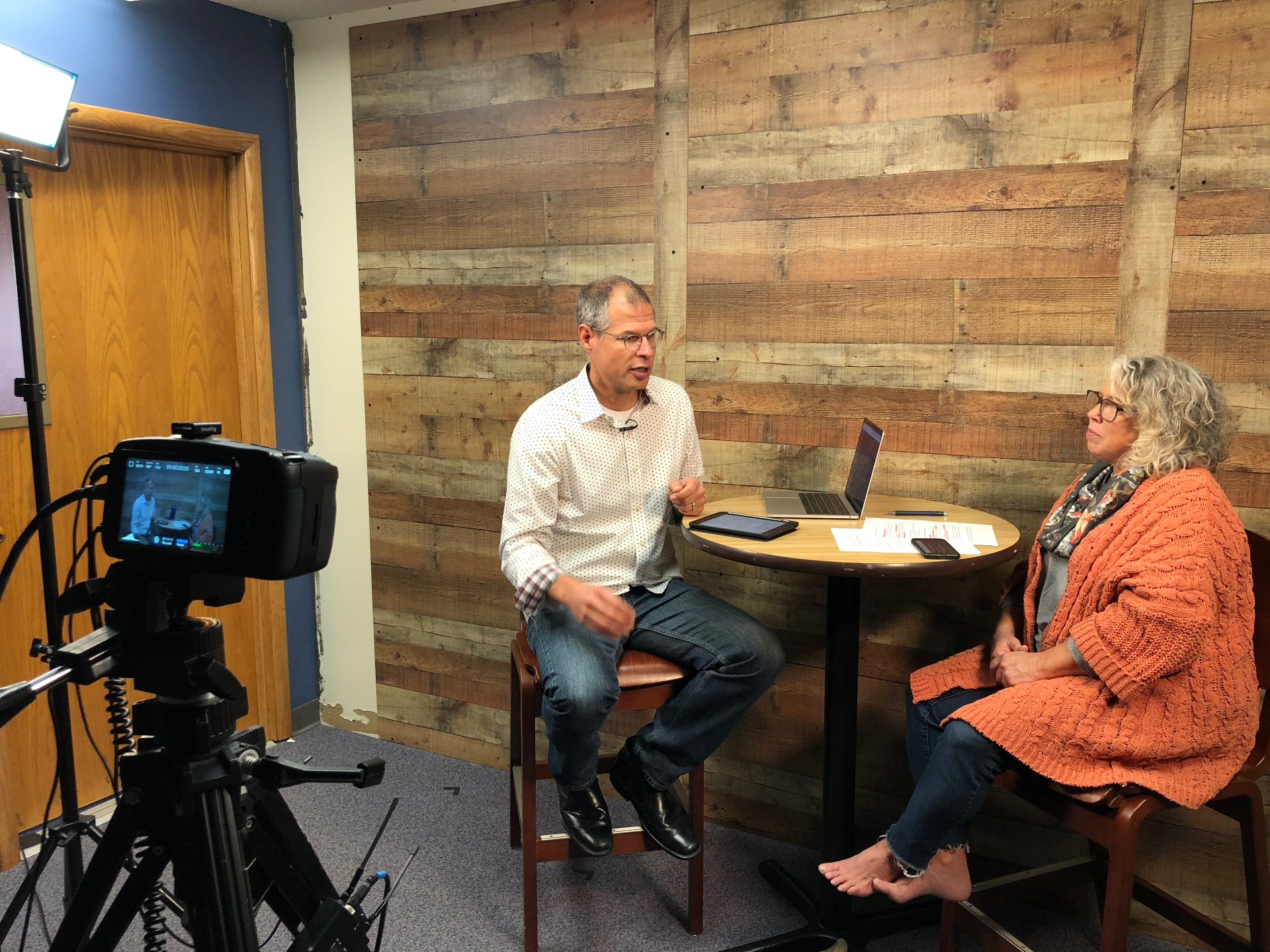 Two people recording a video interview in a studio setting
